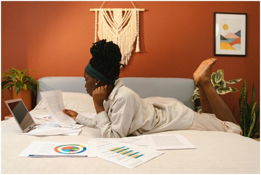 A young woman reads documents and studies on her b