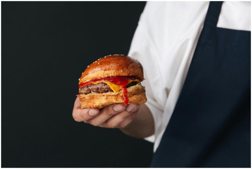 Appetizing cheeseburger with ketchup dripping, hel