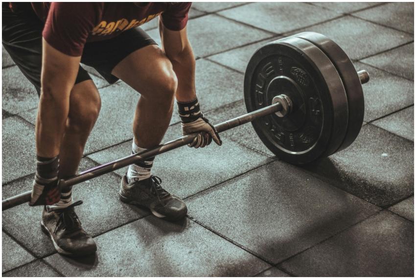 A focused weightlifter prepares to lift a heavy ba