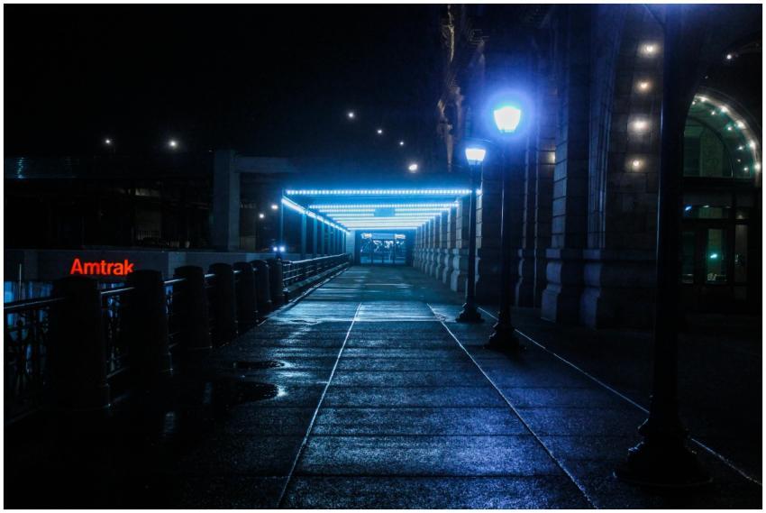 A moody, illuminated pathway at a train station du