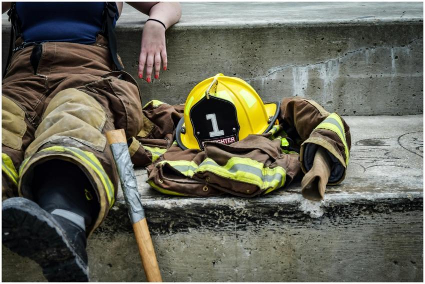 Firewoman taking a break on concrete steps with ge