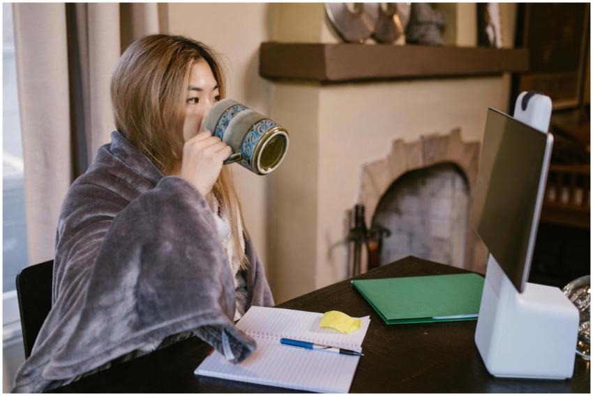 Adult woman sipping coffee while working remotely