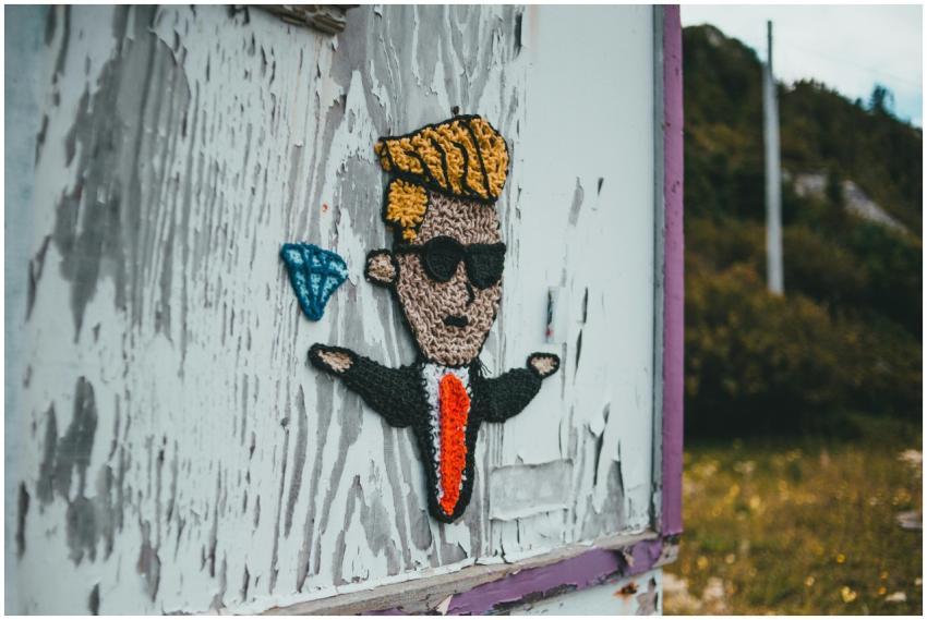 Image of a knitted cartoon figure on a worn wall i