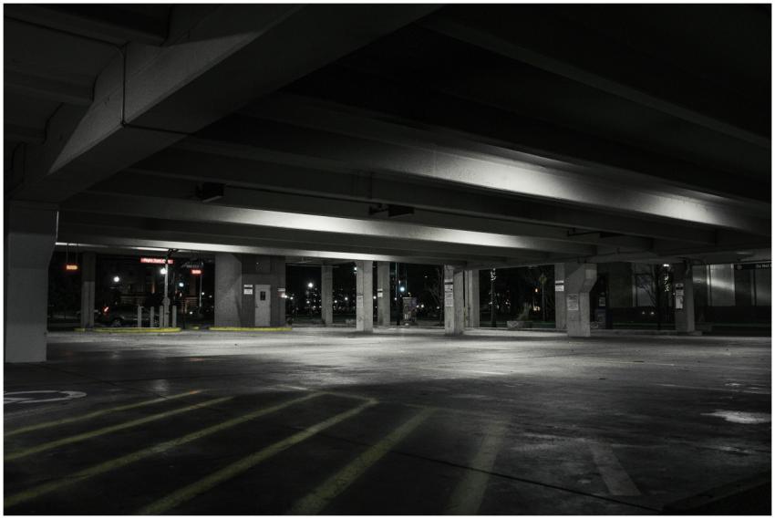 An empty urban parking garage at night with dramat