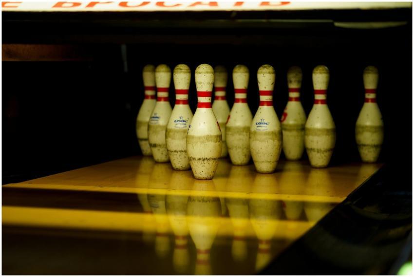 Close-up of arranged bowling pins on a lane, ready