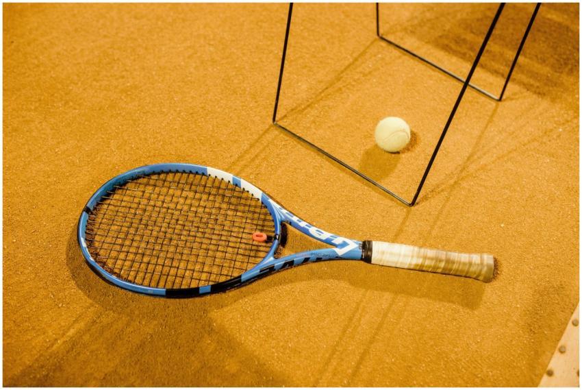 Close-up of a blue tennis racket and ball on an in