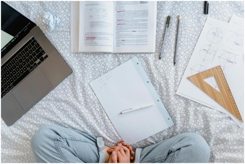 Flat lay of a study area with an open laptop, book