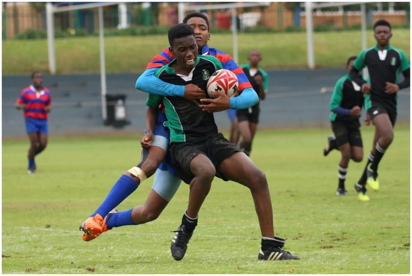 Intense rugby match showcasing a strong tackle on