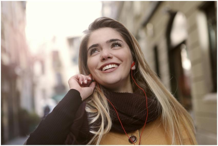 Joyful young woman enjoying music with earphones o