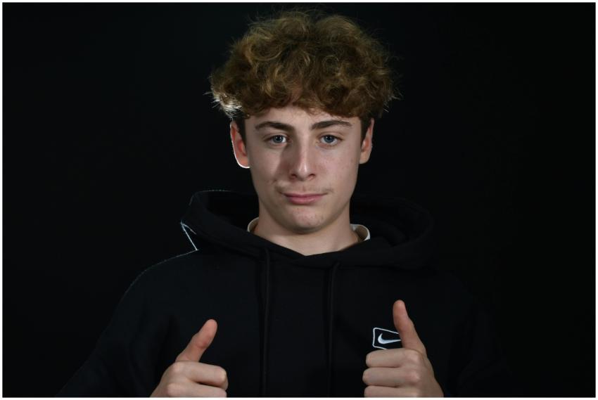 Portrait of a young man in a hoodie with thumbs up