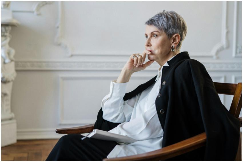Elderly woman sitting thoughtfully in an elegant i