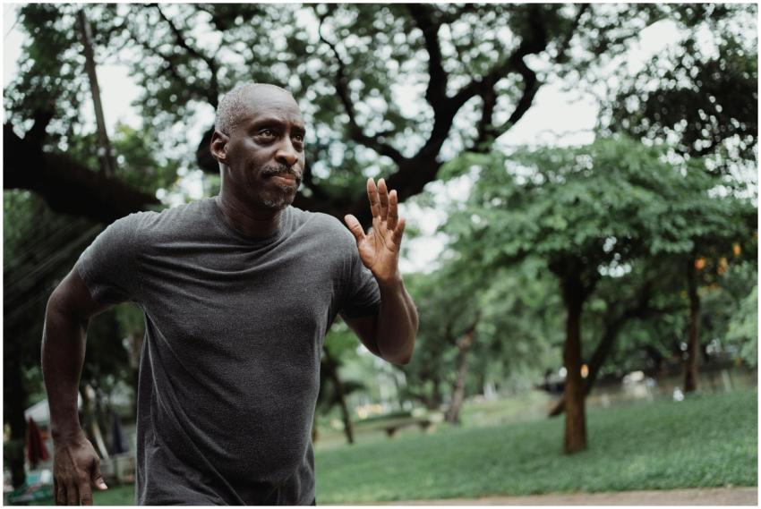 Senior man running through a lush green park, focu