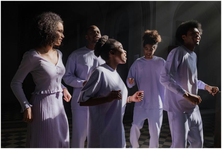 A group of diverse adults singing energetically in