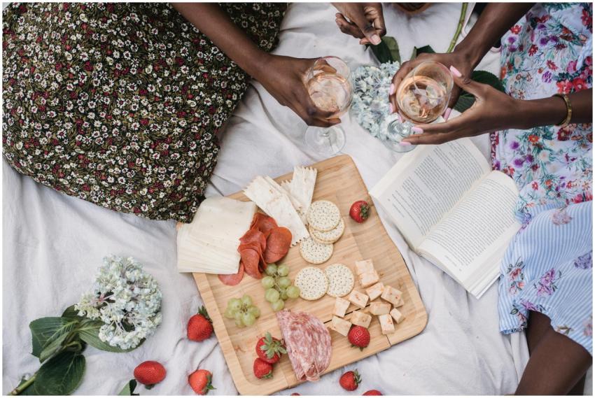 Overhead view of a picnic with wine, snacks, and a