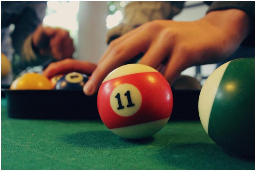Close-up image of hands arranging billiard balls o