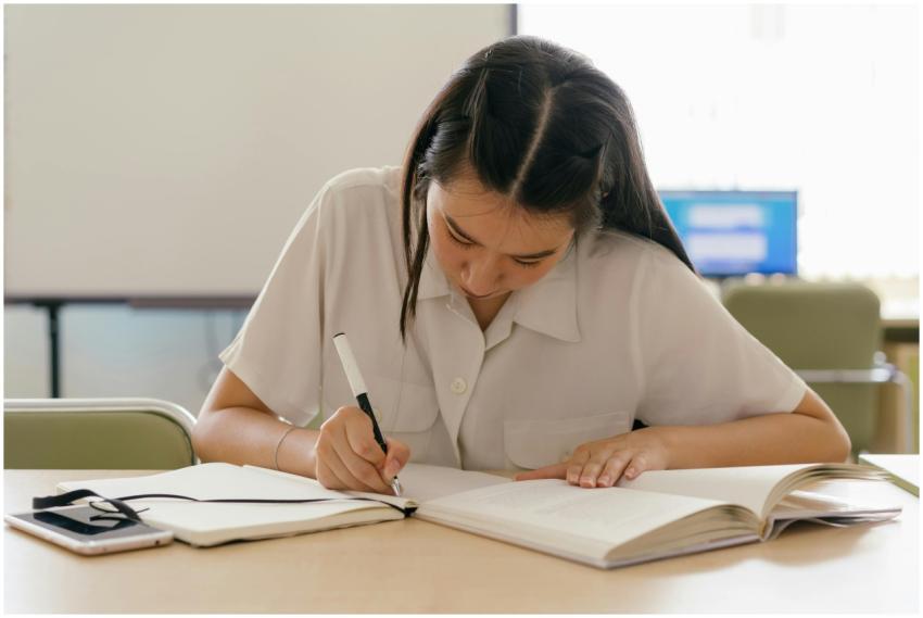 Young woman engaged in studying at a classroom des