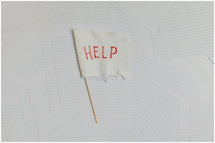 A fabric flag with 'HELP' on a scattered notepaper
