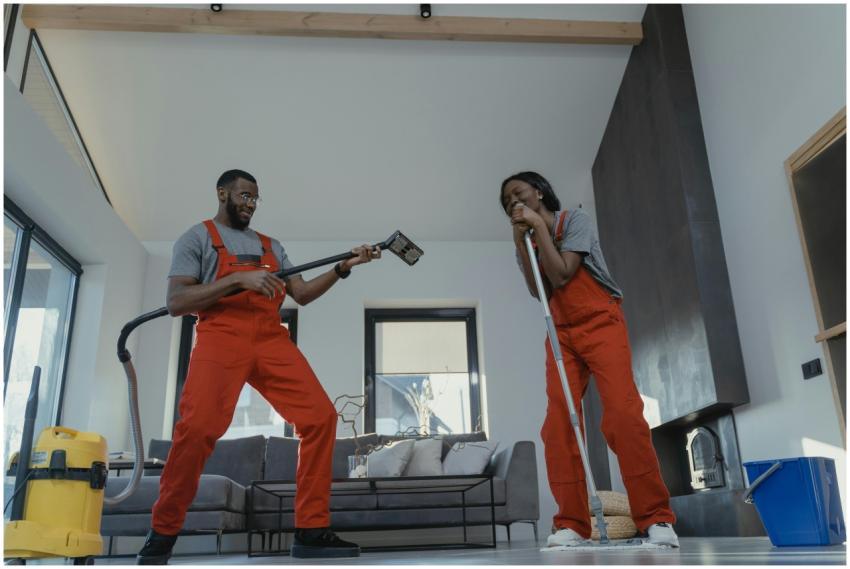 Two adults in red coveralls having fun while clean