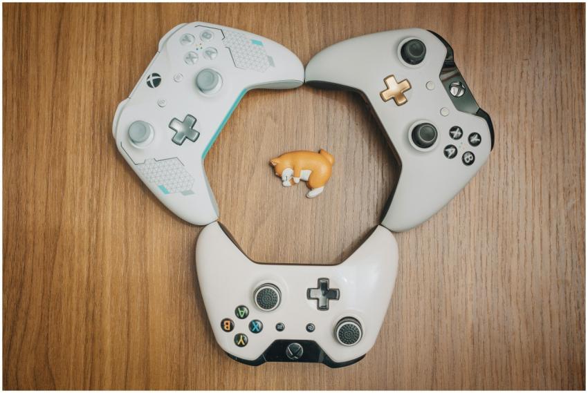Three game controllers arranged in a circle on a w
