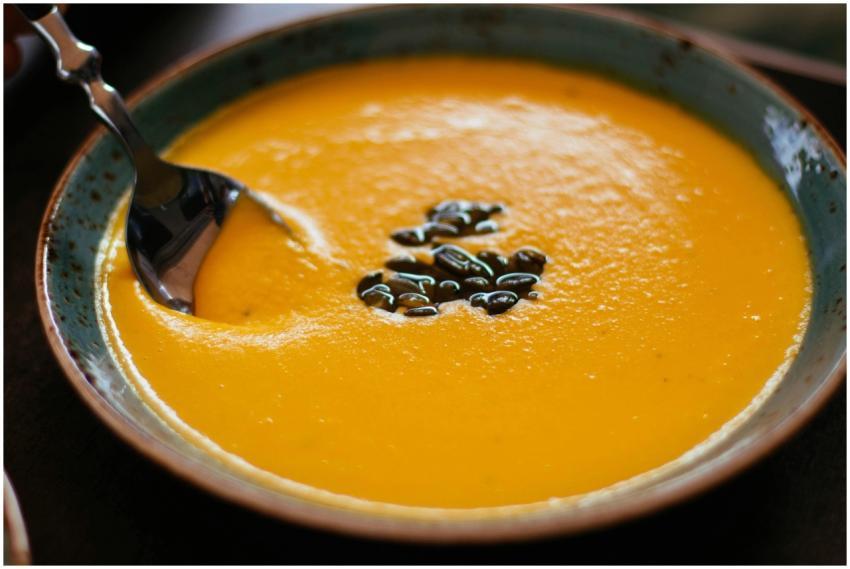 Close-up of creamy pumpkin soup with seeds in a bl