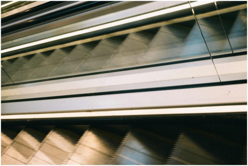 A close-up view of moving escalators with glass ra