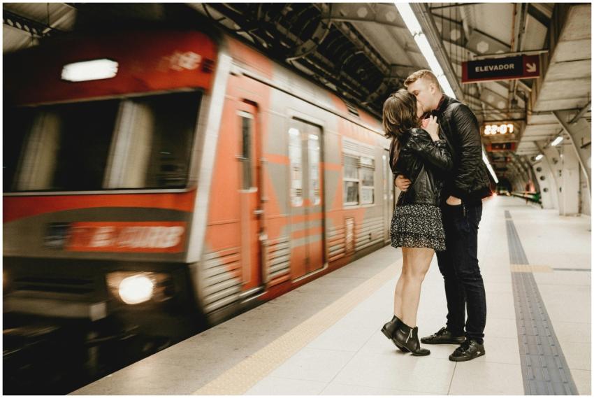 Couple sharing a romantic kiss on a subway platfor