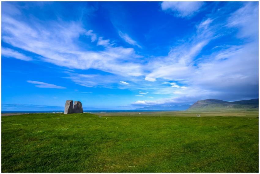 Vast green fields under a vibrant blue sky, featur