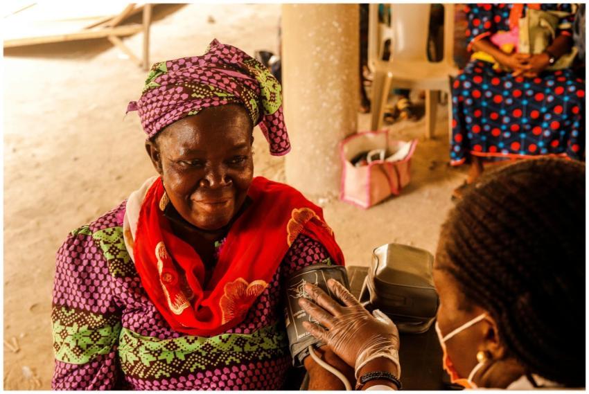 A smiling woman in traditional clothing having her