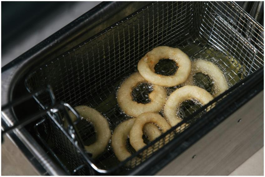 Hot crispy onion rings frying in oil in a deep fry