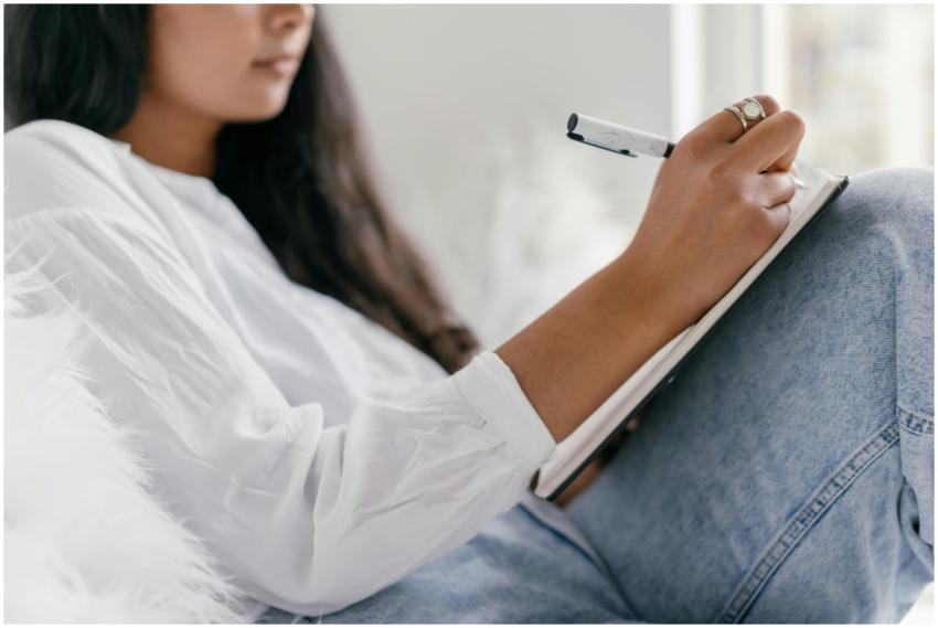 Close-up of a woman writing in a notebook, seated