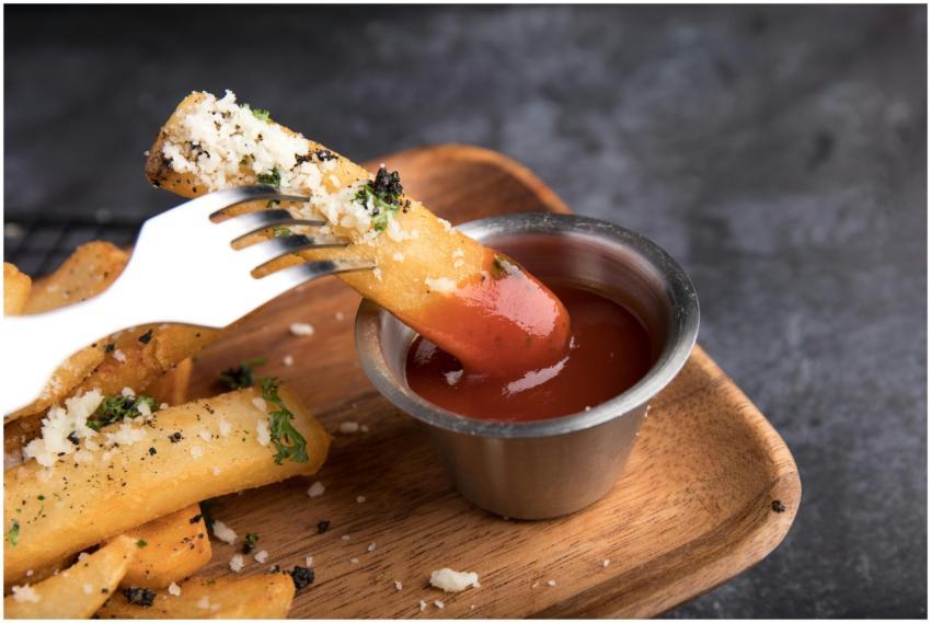 Close-up of parmesan truffle fries dipped in ketch