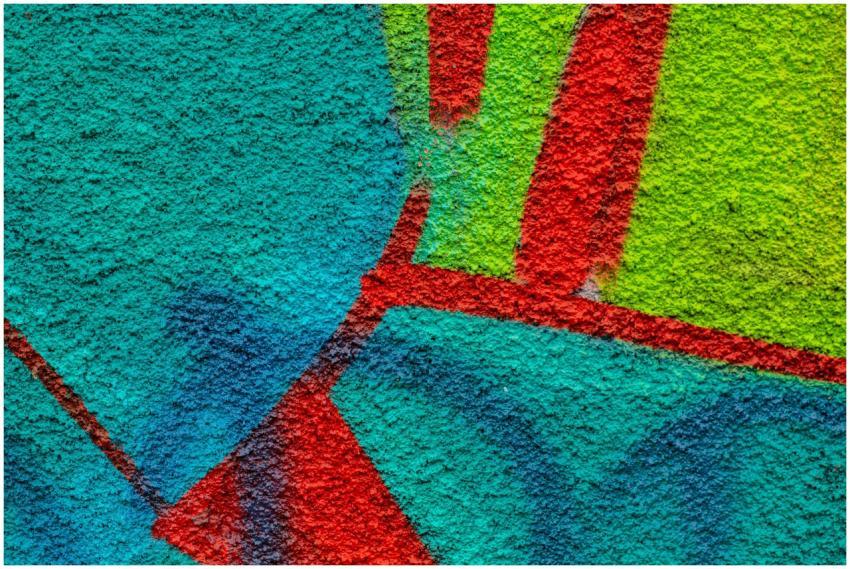Close-up of colorful graffiti on a textured wall s