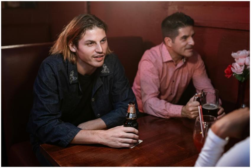 Two men enjoying drinks at a cozy bar table with a