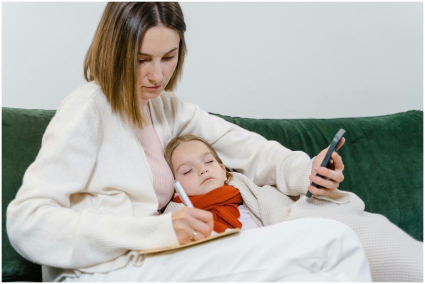 A mother comforts her sick child while writing not