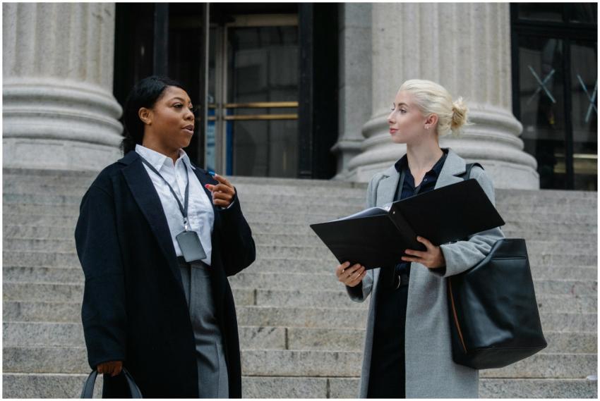 Two professional women in discussion on outdoor co
