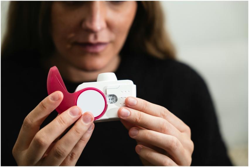 Close-up of a woman holding a medical inhaler devi
