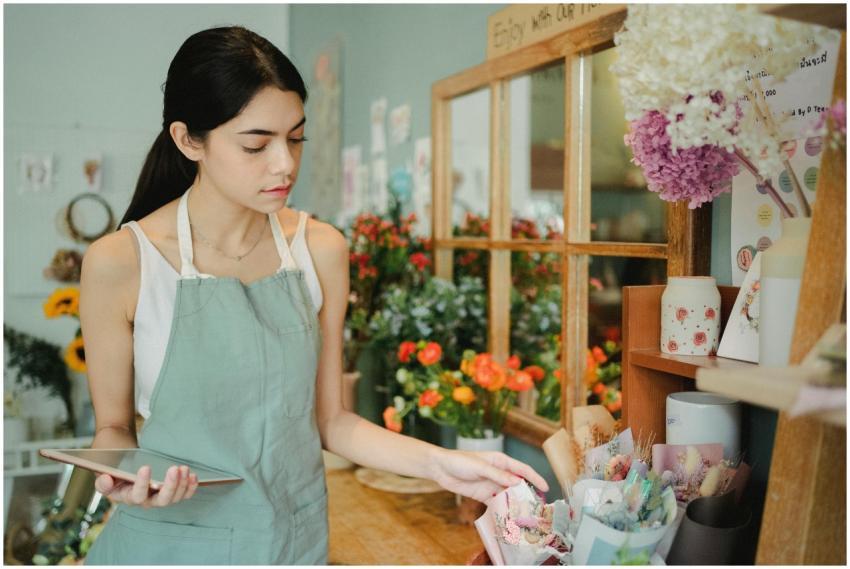 Female florist organizing floral arrangements in a