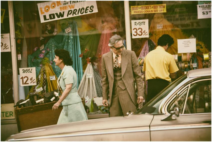 Retro-styled shoppers pass a vintage store in a cl