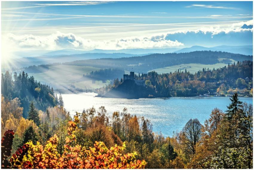 Stunning autumn scenery with sunlit lake and mount