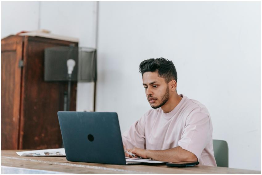 Focused young man working on a laptop in a minimal