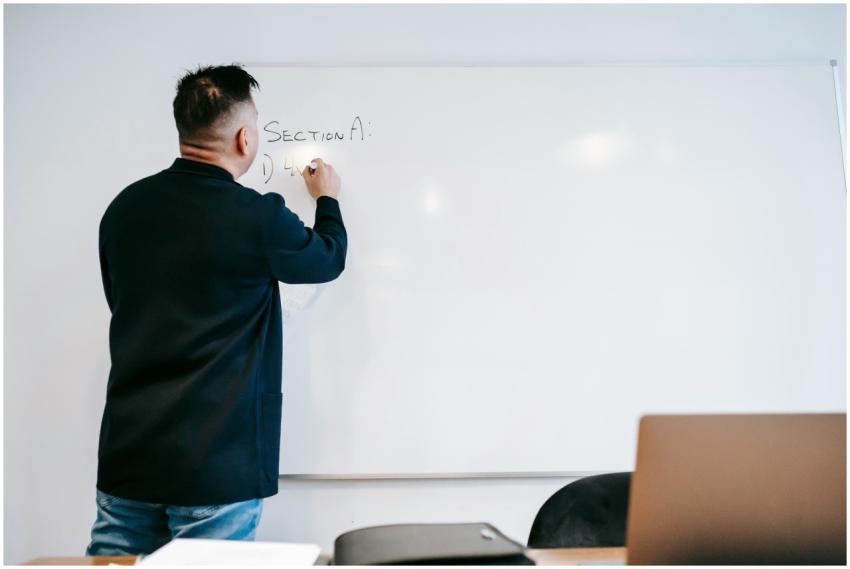 Instructor writing on a whiteboard in a classroom