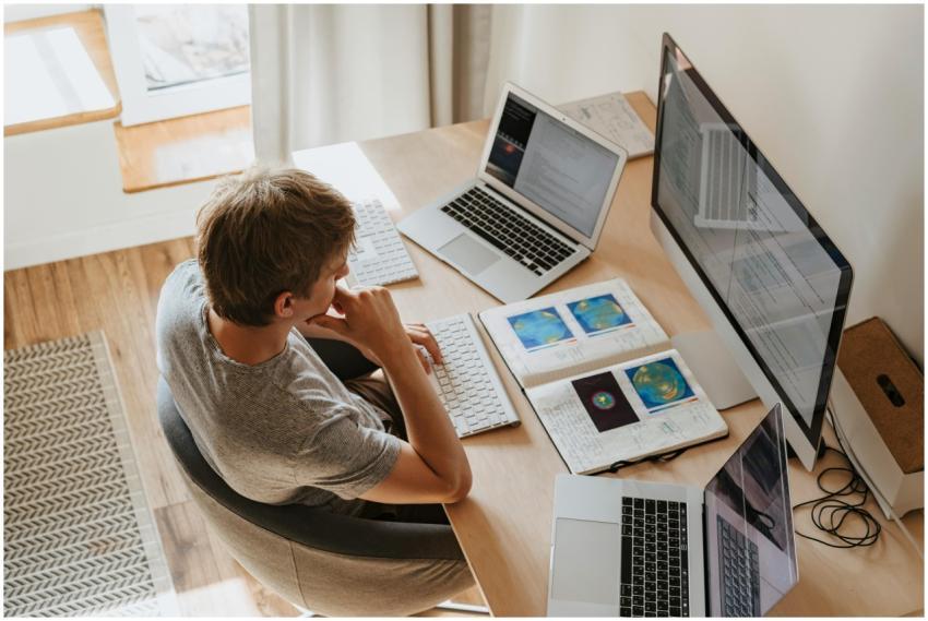 Top view of young programmer working on multiple l