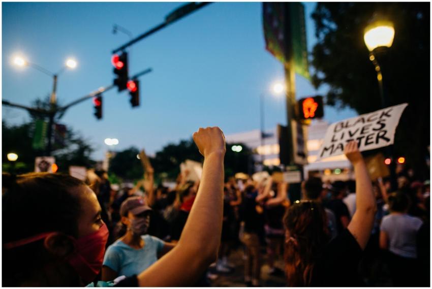 Crowd of protesters with signs and raised fists in