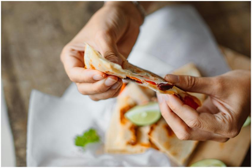 Close-up of a person holding a freshly made quesad