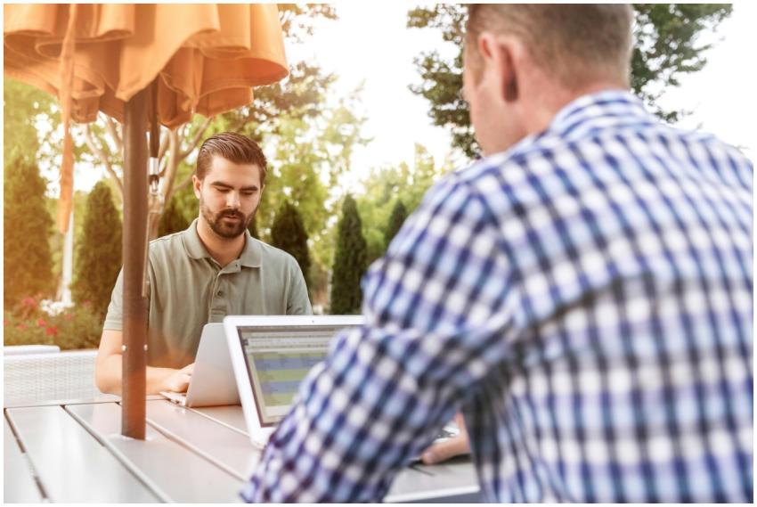 Men working on laptops outdoors, enjoying remote w