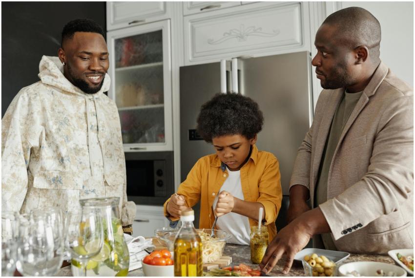 Father and son cooking together in the kitchen, cr