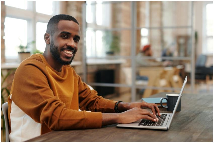 African American man typing on laptop in cozy mode