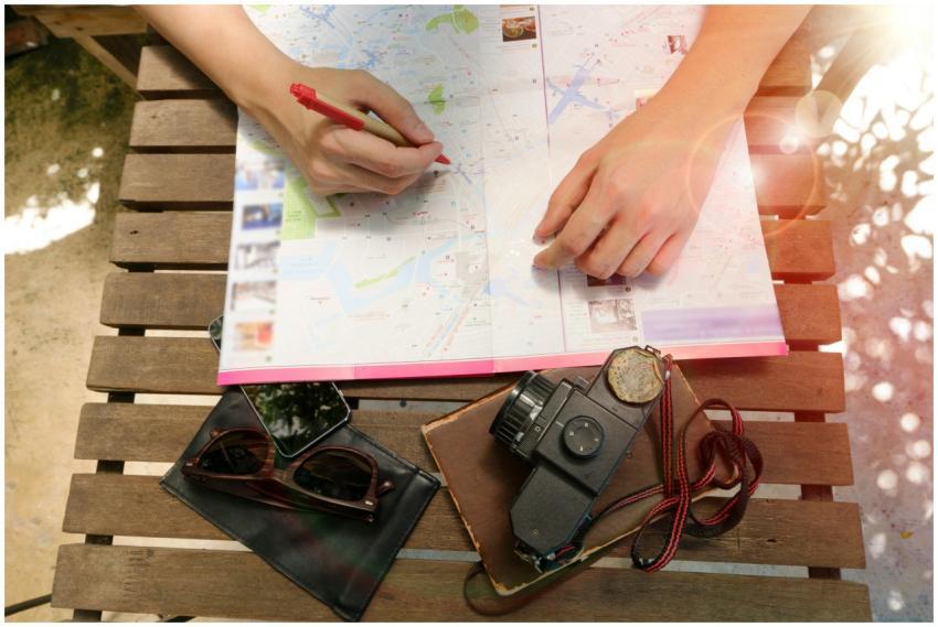 A person planning a journey using a map and vintag