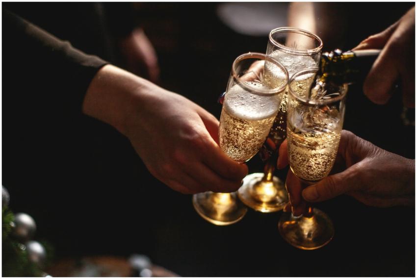 Close-up of hands toasting with champagne glasses,