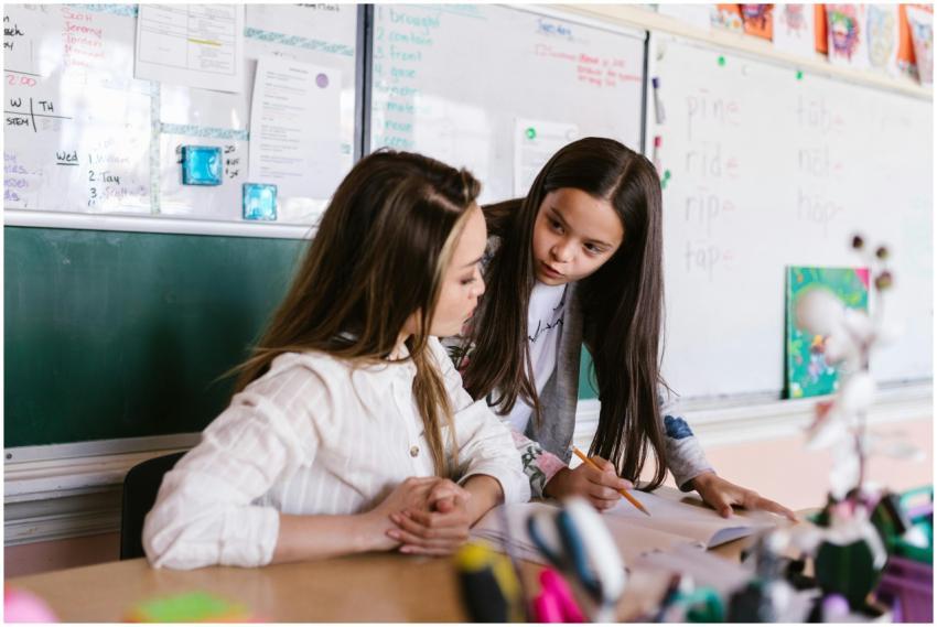 A teacher and student working together at a desk i